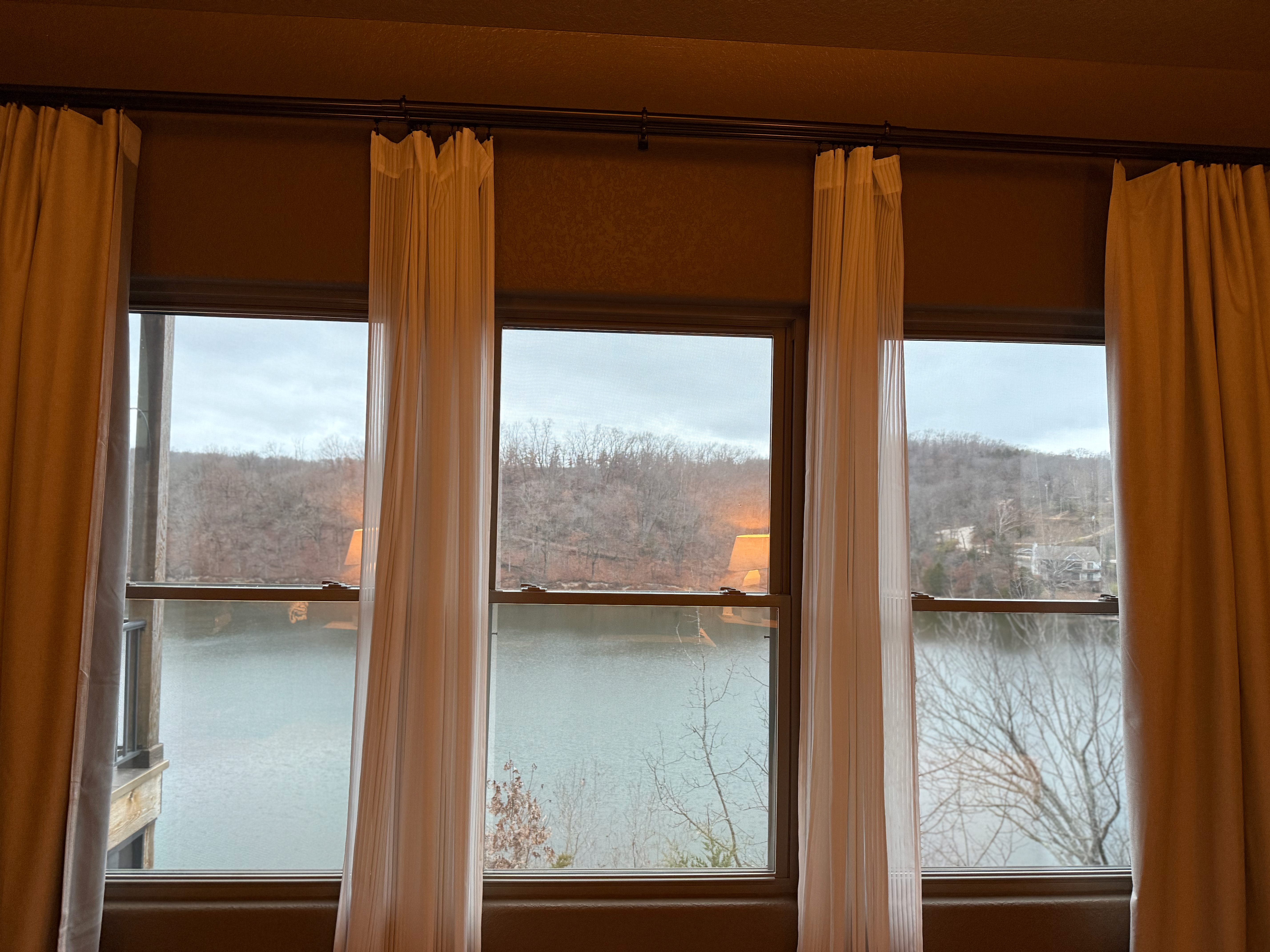 Lake view through bedroom windows at golden hour