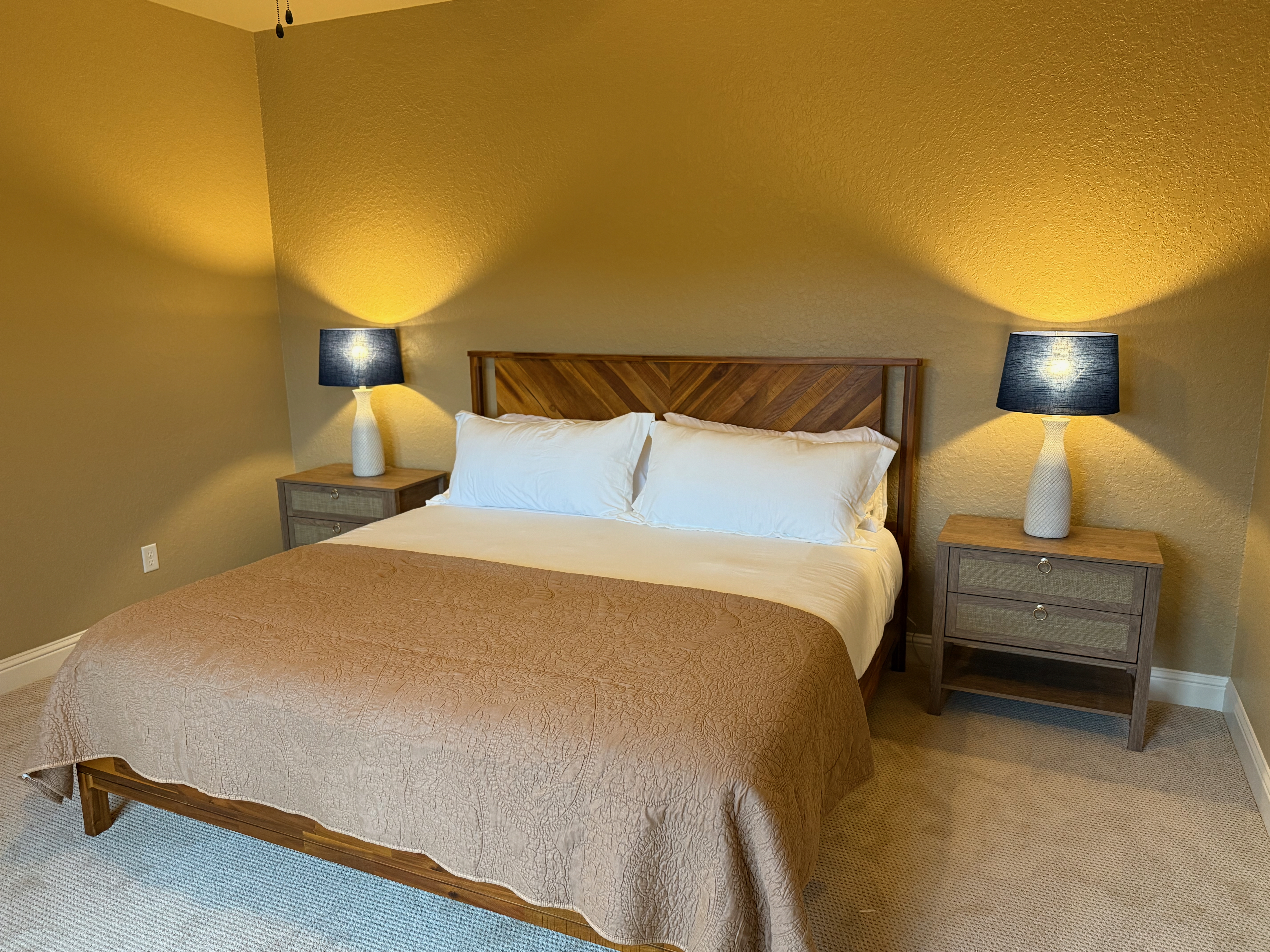 King bedroom with herringbone headboard and tan bedding