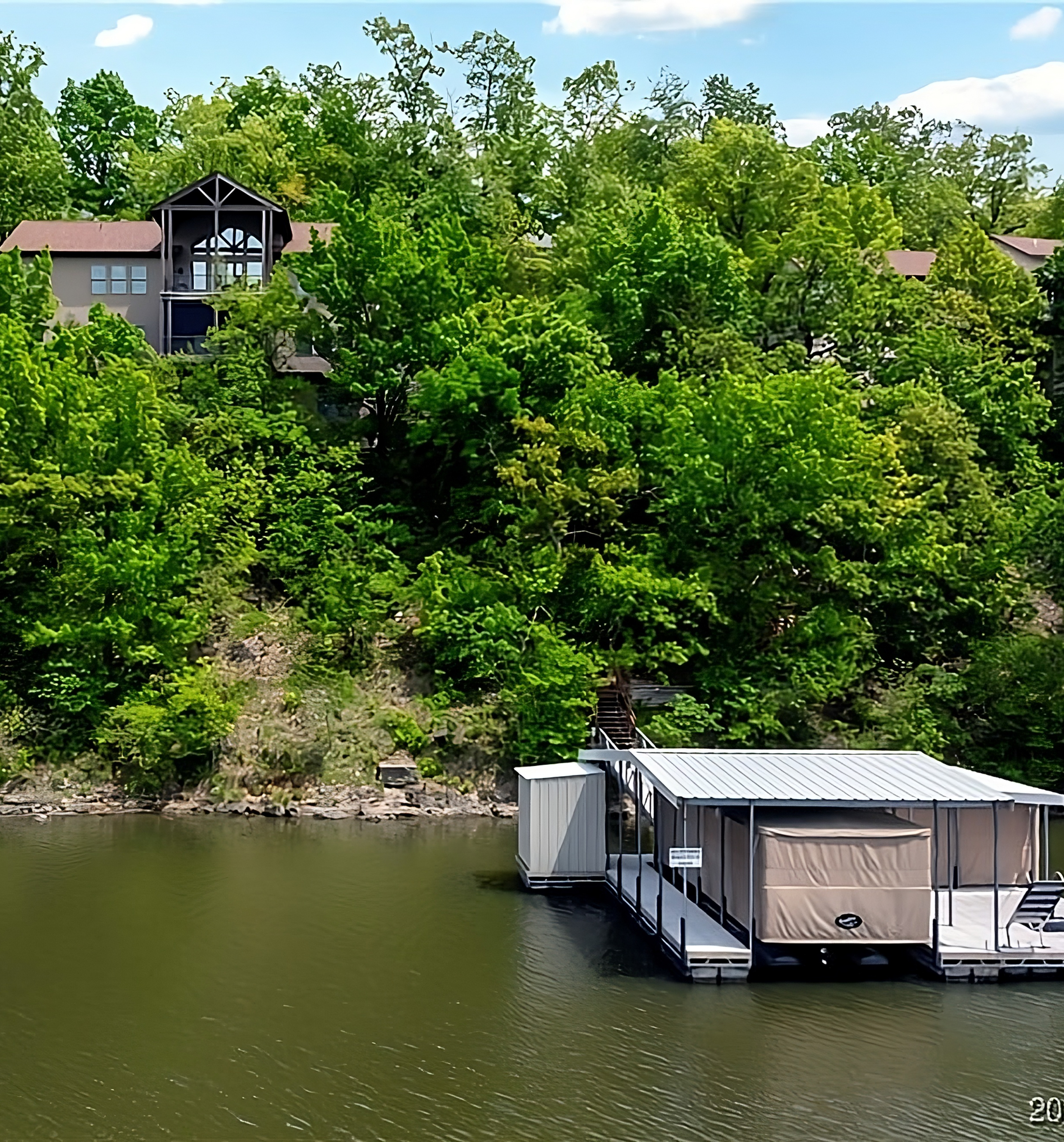View of the house and dock from the cove in summer